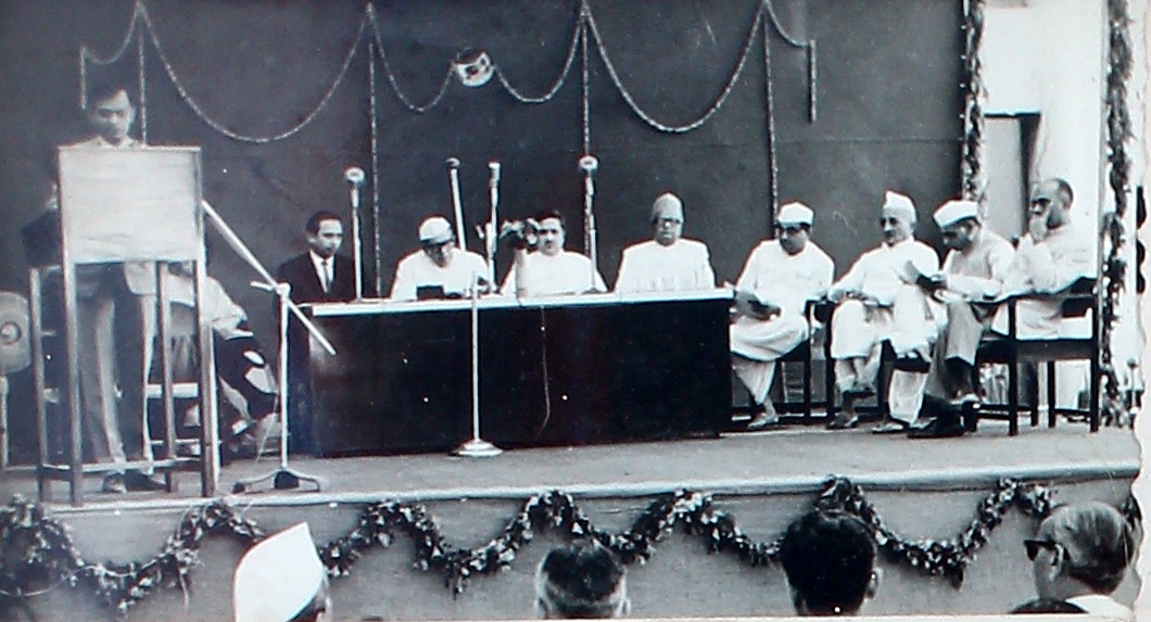 A company function in progress, the platform garlanded and guests seated at a long table.