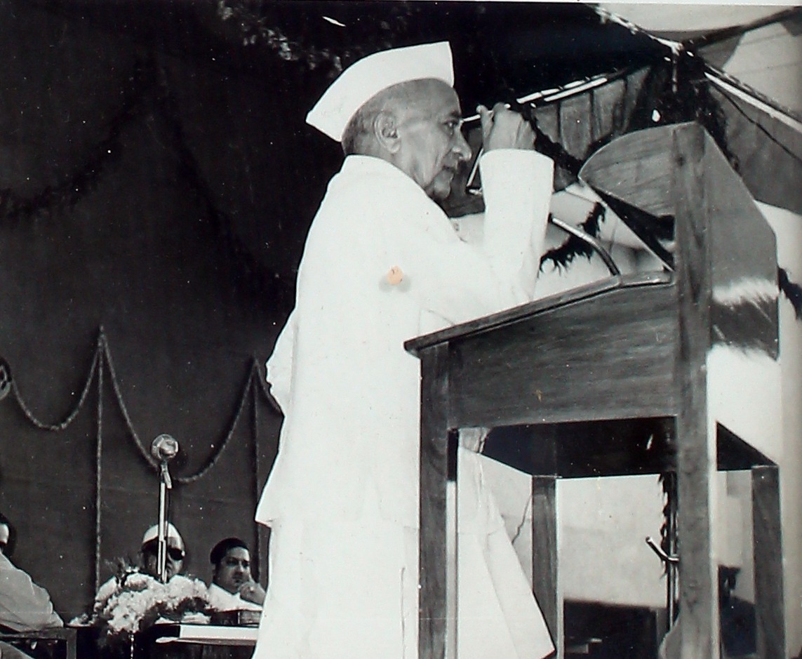 An elderly man speaking from a podium at a company function.