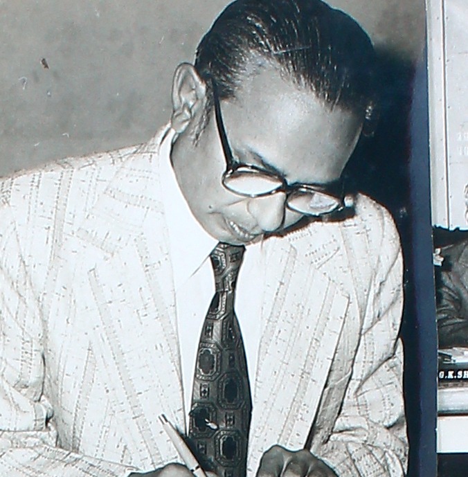 A close view of a man signing a document at a table.